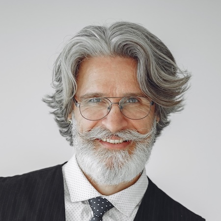 IMG-3Z3Z5K7.jpg Smiling older man with gray hair, mustache, glasses, tie, and vest.