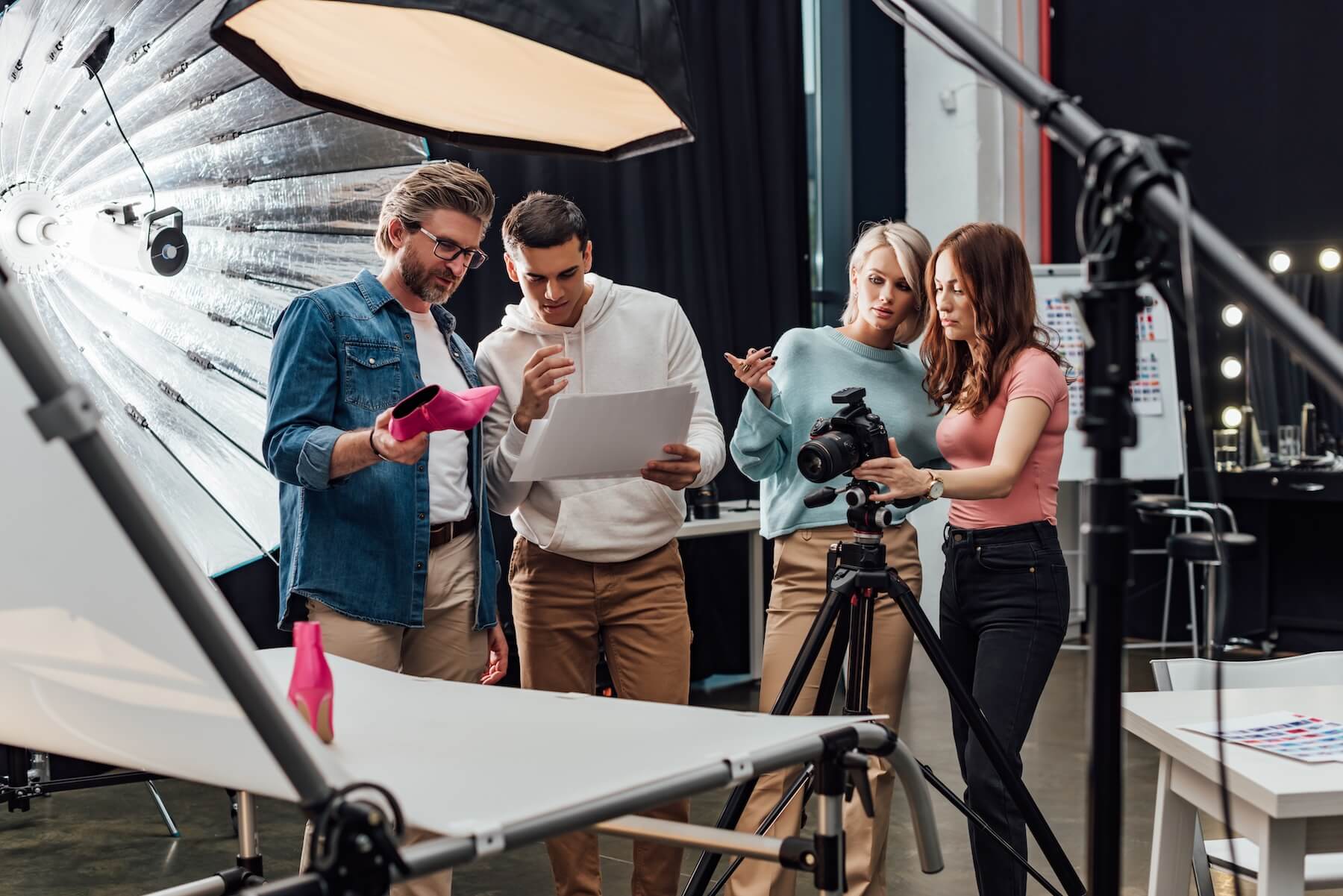 Photo shoot team reviewing images in a studio setting.